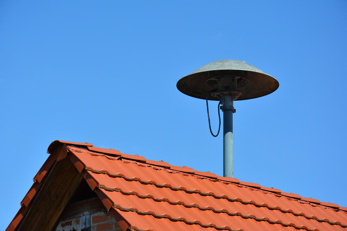 Eine Sirene ist auf dem Dach eines Hauses installiert.