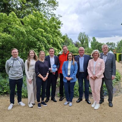 Bei der Vorstellung der Studienergebnisse (von links): Roy Präger vom VfL Wolfsburg, Marleen Stridde von der Audi BKK, Studienkoordinatorin Melanie Lemke vom Universitätsklinikum Hamburg-Eppendorf, Landrat Philipp Raulfs, Miroslav Jenka, Trainer bei den Grizzlys, Projektleiterin Janine Ahrends von der Gesundheitsförderung und Prävention des Landkreises Gifhorn, Norbert Blyszcz, Vorstandsmitglied der Young Grizzlys Wolfsburg, Nele Westphal, Fachbereichsleiterin Kinder, Jugend und Familie beim Kreisverband Gifhorn des Deutschen Roten Kreuzes, und Kreisrat und Gesundheitsdezernent Rolf Amelsberg. Landrat Philipp Raulfs hält das Maskottchen Tobi des Bewegungsprojekts in den Händen.